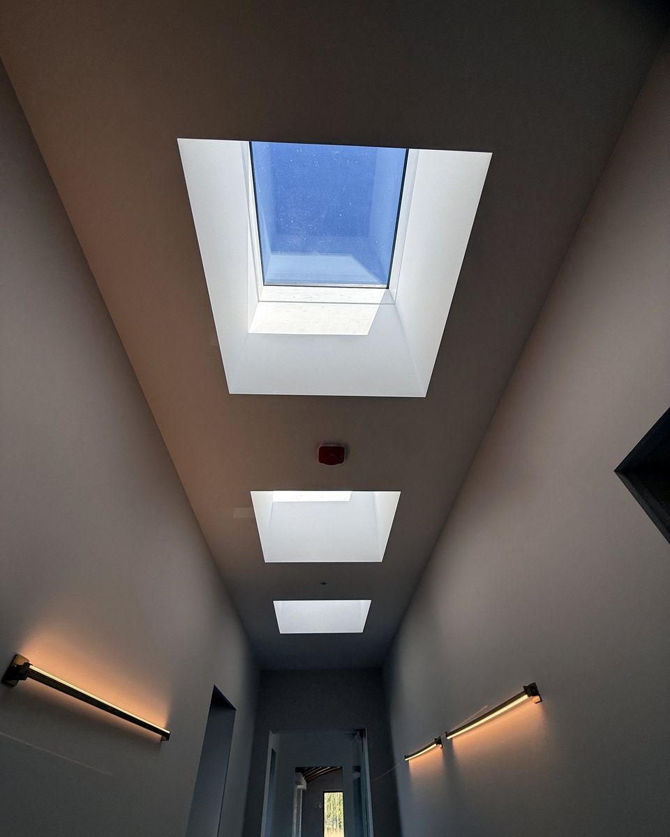 Corridor lit by a row of three rooflights