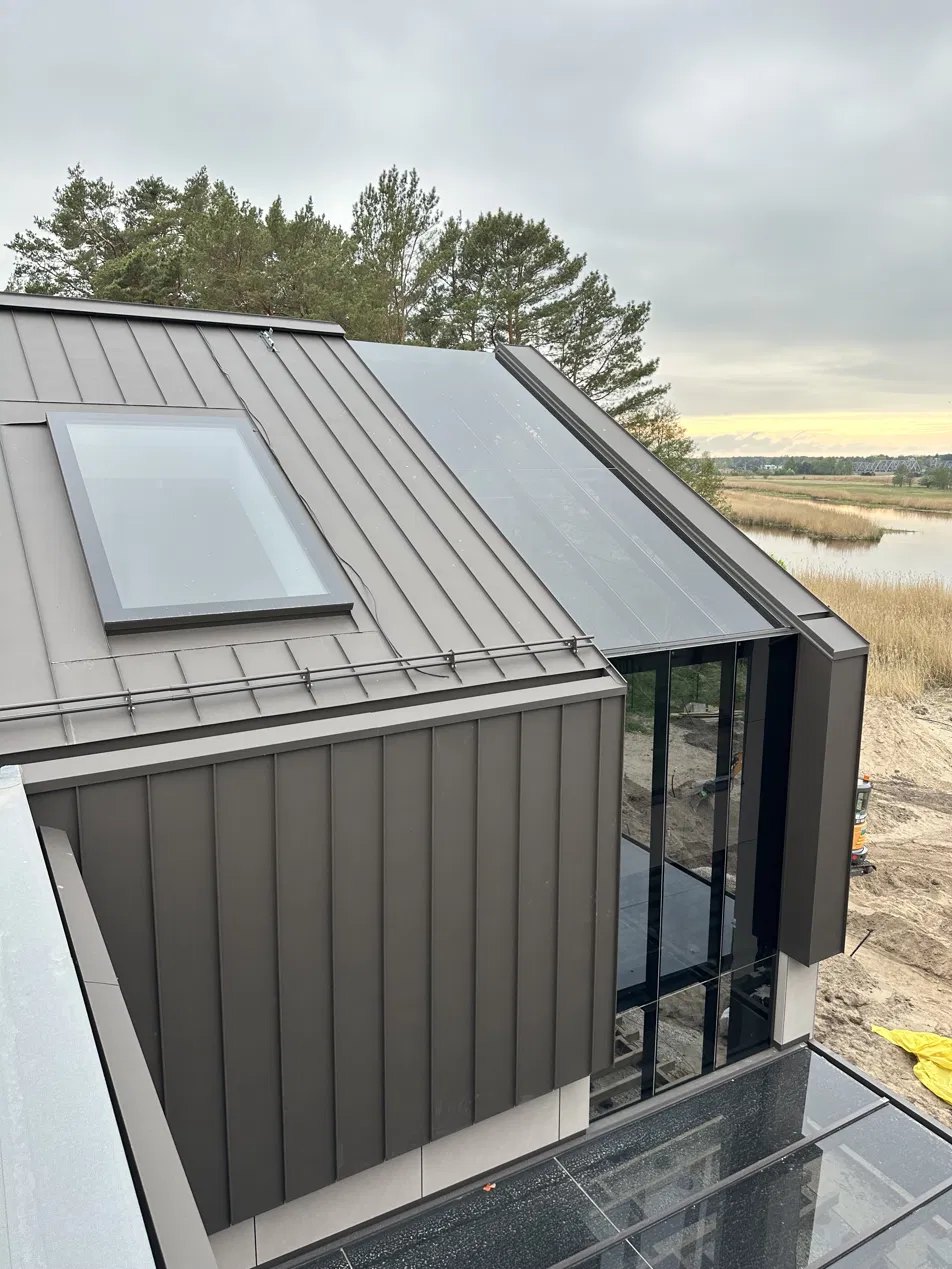 The 1.6 by 2.7 metre bathroom rooflight seen from outside, on a standing-seam metal roof by a river