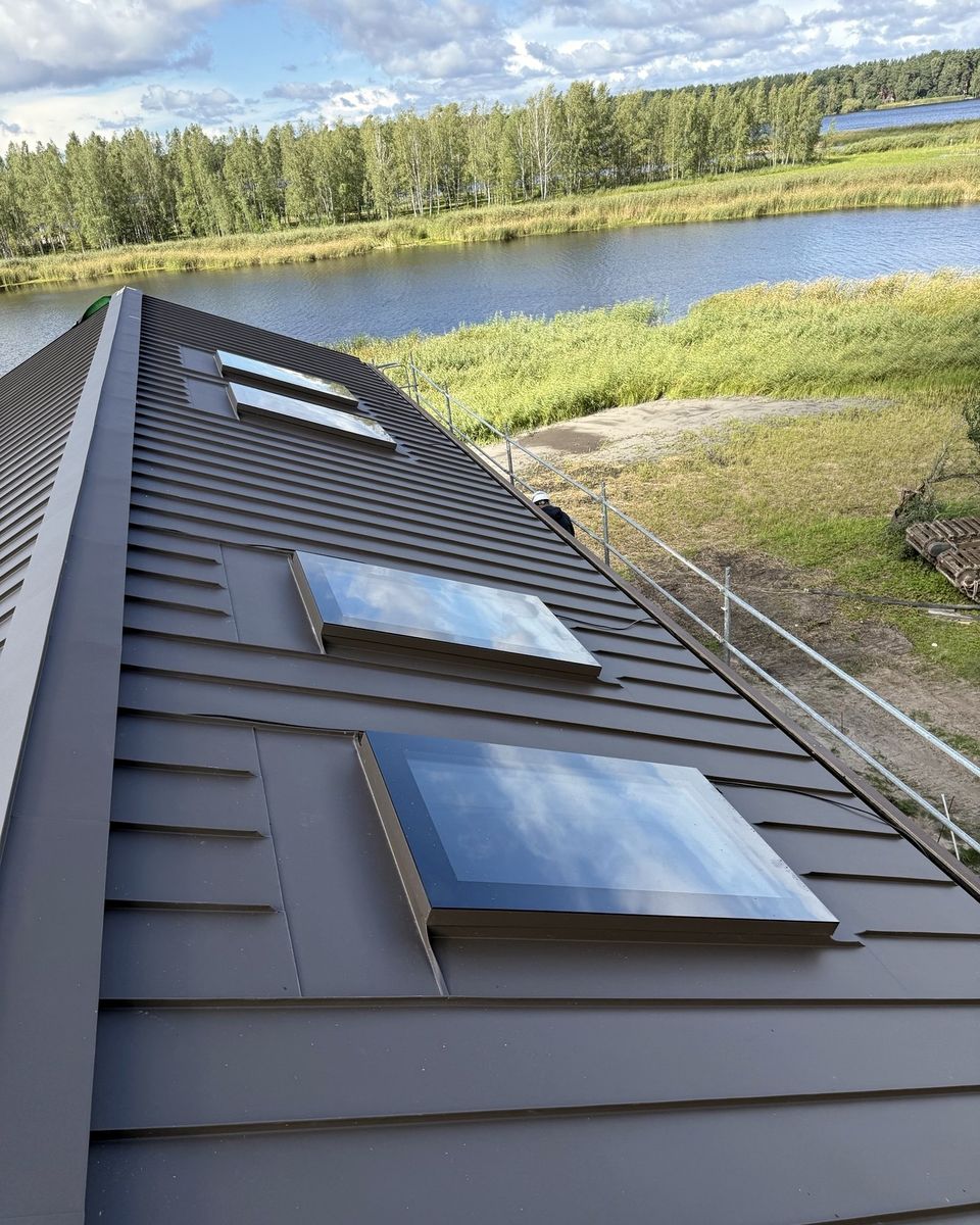 Two rooflights on a pitched standing-seam roof by a lake